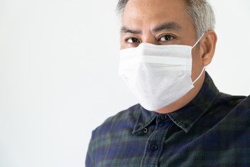 Old man with gray hair under face mask covering mouth and nose.  Corona Virus or COVID-19 concept.