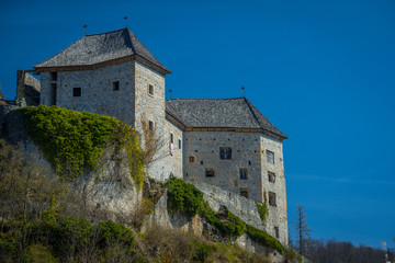 Fototapeta na wymiar View of partially restored medieval castle of Kostel in the village of Kostel, close to Kolpa, Slovenia, on a sunny day with clear blue sky. Beautiful castle panorama.