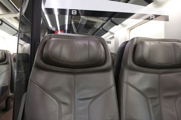 Row of Passenger's brown leather seat of first class on high speed train, empty comfortable luxury vehicle chair, public transportation backgrounds