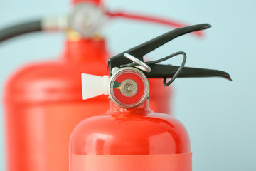 Fire extinguishers on color background, closeup