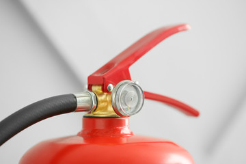 Fire extinguisher on grey background, closeup