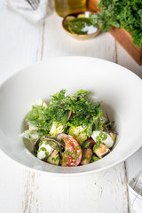 Eggplant salad with fresh herbs, served in a white plate