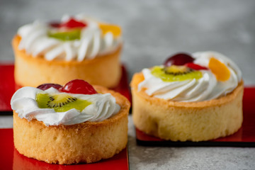 Cakes with whipped cream and slices of fruit