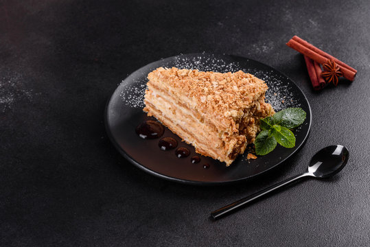 Fresh delicious cake napoleon with cream on a dark background