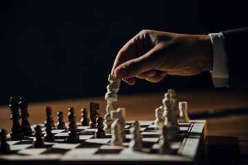 Close up of hands of men playing chess.	
