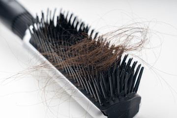 comb and women's hair , hair loss concept, selective focus, white background