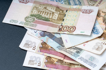 Russian hundred-ruble bills on a dark background, the concept of the Russian economy's recession, selective focus