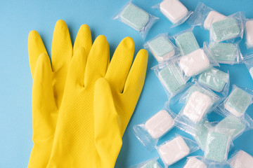 yellow gloves for washing up liquid and dishwasher tablets, toned image, selective focus
