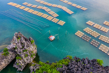 Aerial view fishing village and rock island, Bai Tu Long Bay, Vietnam, Southeast Asia. UNESCO World Heritage Site. Junk boat cruise to Ha Long Bay. Popular landmark, famous destination of Vietnam