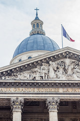 The Pantheon in Paris with the French flag flying above. Taken during the daytime.
