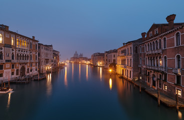 Fototapeta na wymiar VENICE, ITALY - February 17, 2020: Foggy morning at Grand Canal and in the background the Basilica Santa Maria della Salute,view from Ponte dell' Accademia bridge 