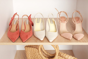 Stylish female shoes on shelf in wardrobe