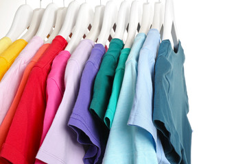 Rack with hanging clothes on white background, closeup