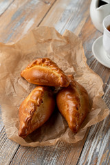 Traditional russian buns, stuffed with a filling, served on wooden table