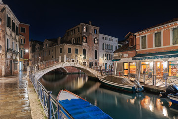 VENICE, ITALY - February 19, 2020: Night view of the romantic Venice with restaurants , bridges and canals
