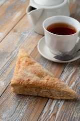 Puff pastry triangle with sugar as a simple treat to a cup of black tea