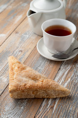 Puff pastry triangle with sugar as a simple treat to a cup of black tea
