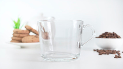Glass cup with granules of instant coffee over on white background. Close up.