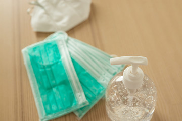 Medical face mask with alcohol sanitizer gel hand wash on wood table for covid-19 Coronavirus prevention concept