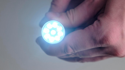 Close up for male hand holding flashlight.