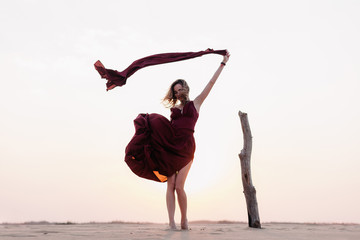 wind inflates a girl's dress in the desert