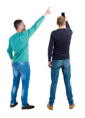 Back view of two man in sweater with mobile phone.