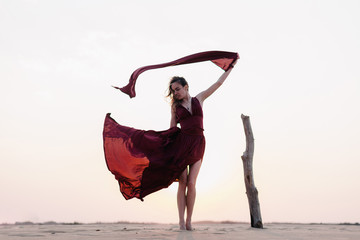 wind inflates a girl's dress in the desert