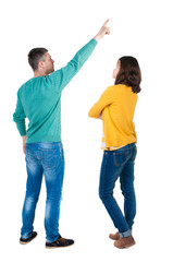 Back view of couple in sweater pointing.