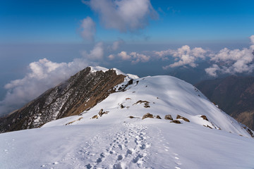 Fototapeta na wymiar Footprint on snow on top of mountain ridge lead to upper view point of Mardi Himal trekking route, Himalaya mountains range in Nepal