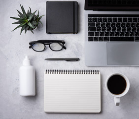 Home work. Business flat lay with sanitizer, note, pencil, eye glasses, notebook and cucculent, on white beton background