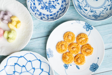 Thai Traditional Cookie on Blue Dish and Wooden Round Board with Blue Rustic Old Wooden Table