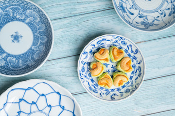 Thai Traditional Cookie on Blue Dish and Wooden Round Board with Blue Rustic Old Wooden Table