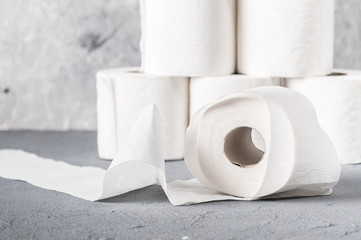 Rolls of toilet paper on grey textured surface