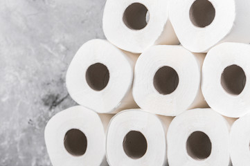 Rolls of toilet paper on grey textured surface