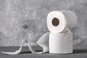 Rolls of toilet paper on grey textured surface