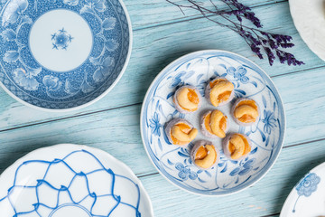 Thai Traditional Cookie on Blue Dish and Wooden Round Board with Blue Rustic Old Wooden Table