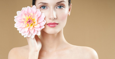 Fototapeta na wymiar beautiful woman with pink flower. perfect skin. fashion model with flowers. Professional makeup.