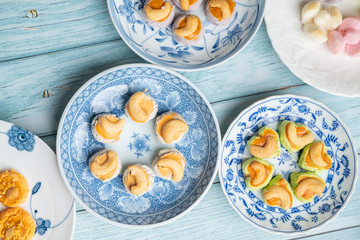 Thai Traditional Cookie on Blue Dish and Wooden Round Board with Blue Rustic Old Wooden Table