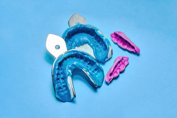 Two dental impressions on a white and blue background. The imprint of the tooth row of high precision and bite registration pieces