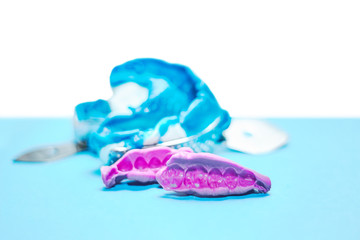 Two dental impressions on a white and blue background. The imprint of the tooth row of high precision and bite registration pieces