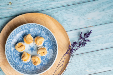 Thai Traditional Cookie on Blue Dish and Wooden Round Board with Blue Rustic Old Wooden Table