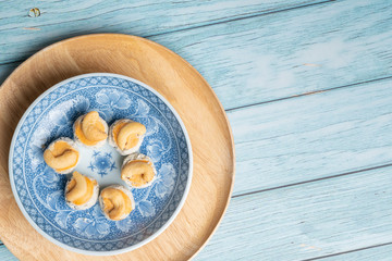 Thai Traditional Cookie on Blue Dish and Wooden Round Board with Blue Rustic Old Wooden Table