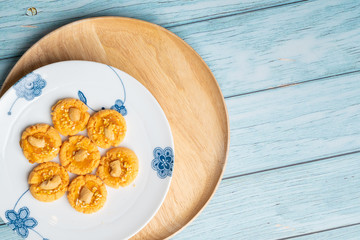 Thai Traditional Cookie on Blue Dish and Wooden Round Board with Blue Rustic Old Wooden Table