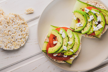 Rice cake with sliced avocado and tomato top view: healthy eating concept