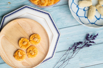 Thai Traditional Cookie on Blue Dish and Wooden Round Board with Blue Rustic Old Wooden Table