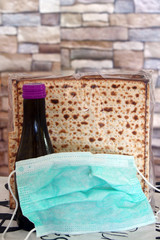 Corona Passover. Dust mask, bottle of wine and matzah - a traditional Jewish food for Passover