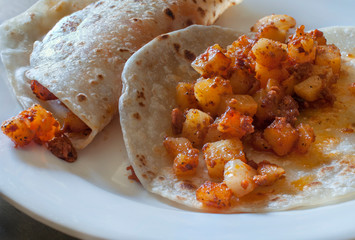 Potatoe and chorizo tacos in flour tortillas as part of a Mexican breakfast, traditional Mexican food.