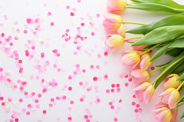 flower background of pink tulips and confetti