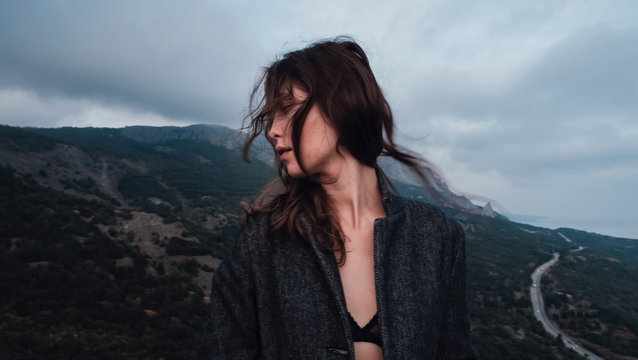 Asian woman in a gray coat enjoying the view in the mountains
