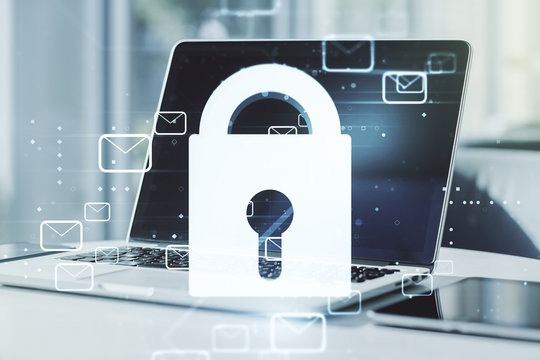 Double exposure of creative lock hologram with email symbols on laptop background. Information security concept